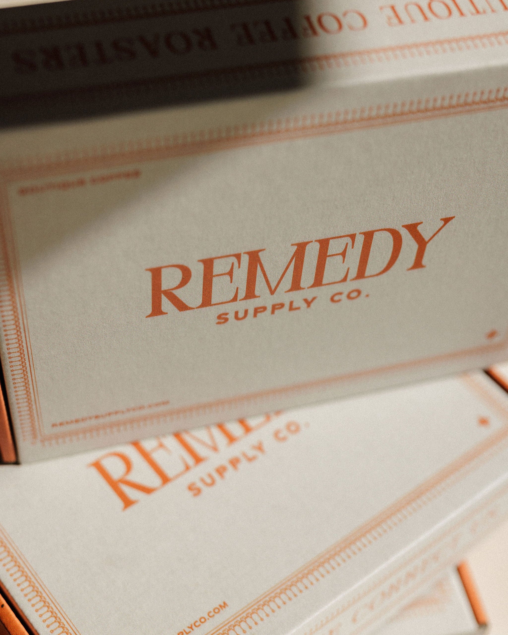 Remedy Supply Co. branded cardboard boxes stacked together, with the company name printed in orange on a light beige box.